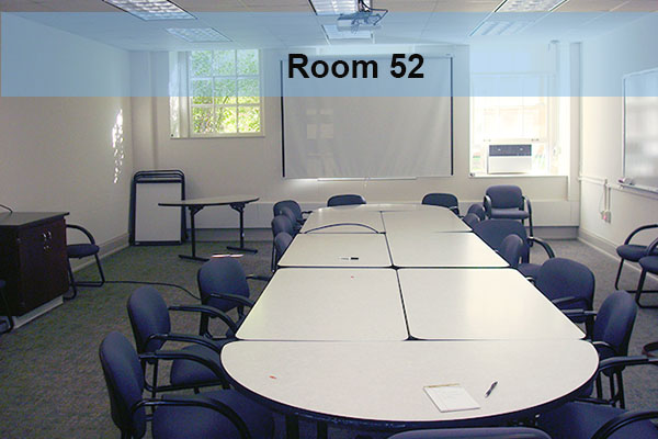A conference room table and chairs, with a projector and screen