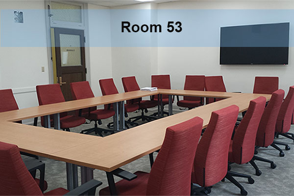 Conference room tables and chairs with a wall mounted monitor
